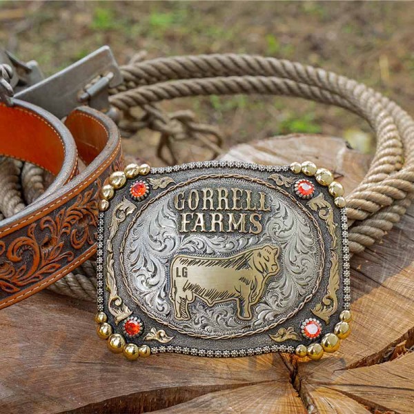 A custom farming belt buckle for Gorrell Farms featuring a cow figure